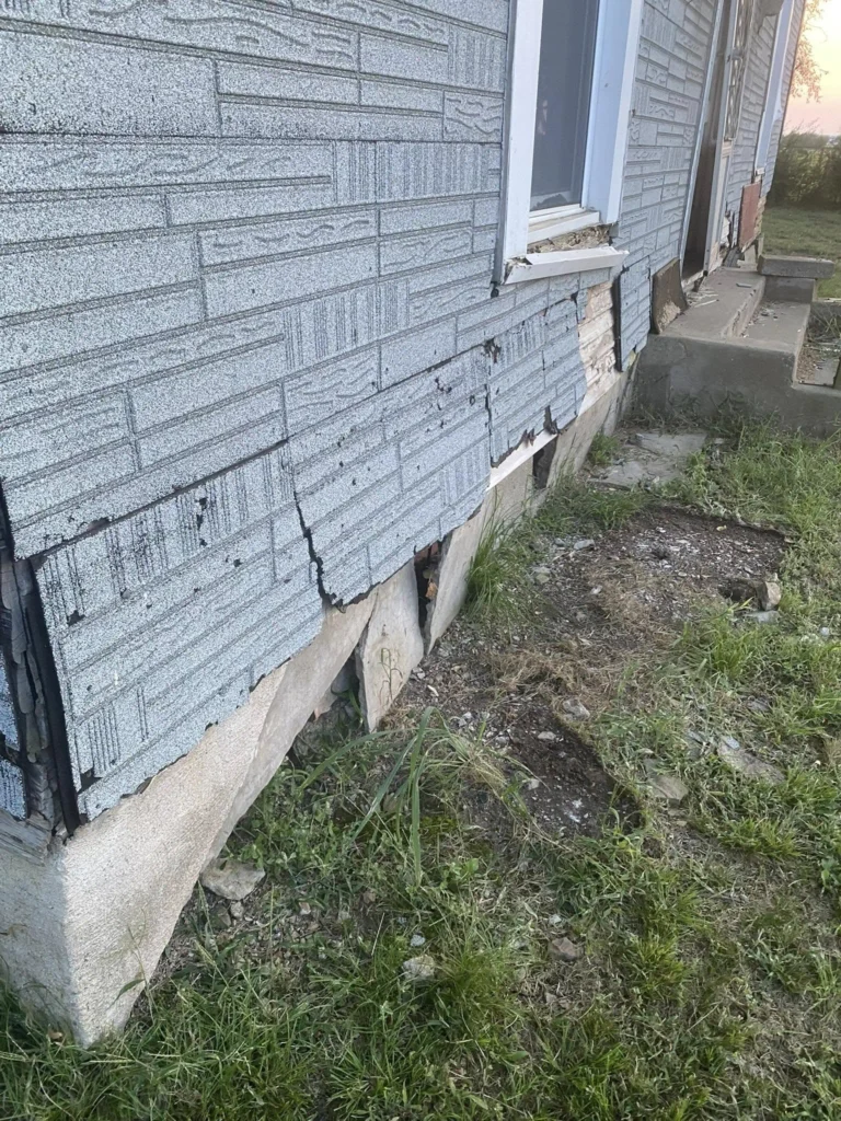 Contractor installing crawl space insulation beneath a Tulsa house